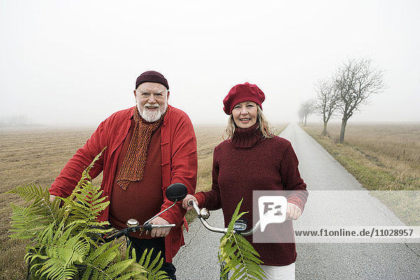 An old couple on a bicycle excursion.