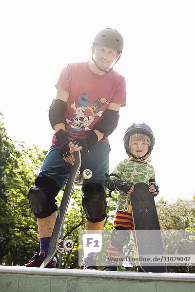 Vater mit Sohn halten Skateboards