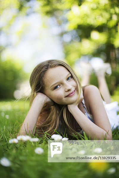 Girl lying on lawn  smiling  portrait