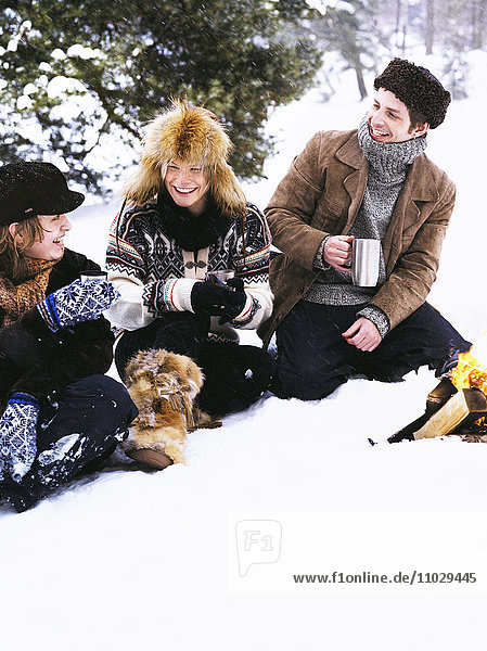 Drei Personen bei einem Winterpicknick.