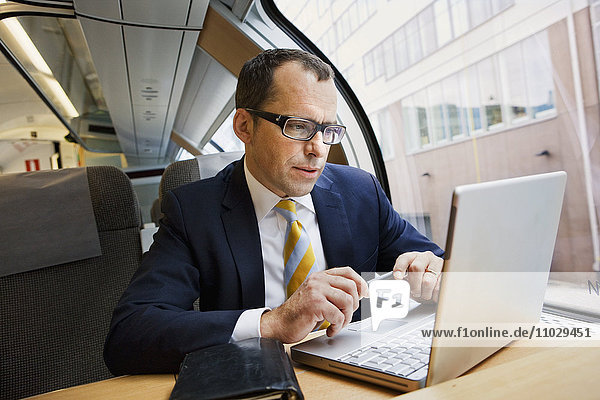 Businessman using laptop on high speed train