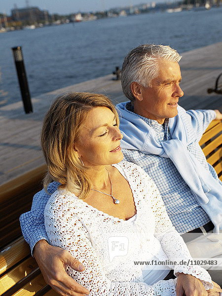 Middle-age couple sitting on a bench.