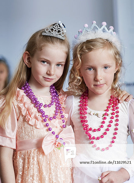 Porträt von zwei Mädchen in eleganten Kleidern und mit Halsketten