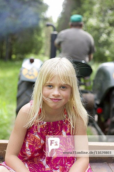 Porträt eines Mädchens  Traktor im Hintergrund