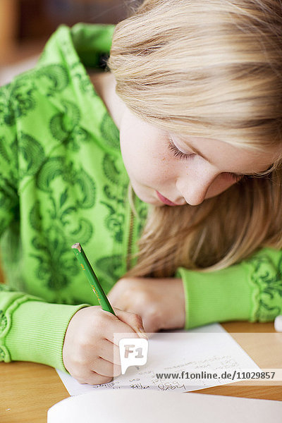 Schulmädchen schreibt auf Papier