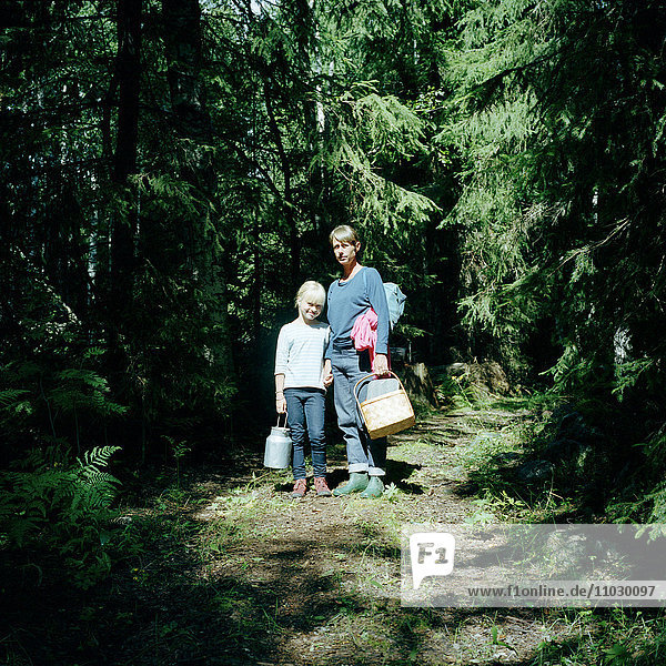 Mutter mit Kindern beim Pilzesammeln im Wald