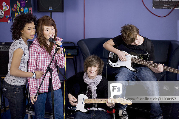 Teenagers playing guitars and singing