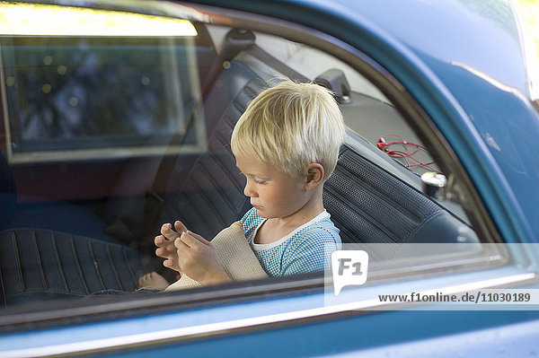 Junge auf dem Rücksitz eines Autos
