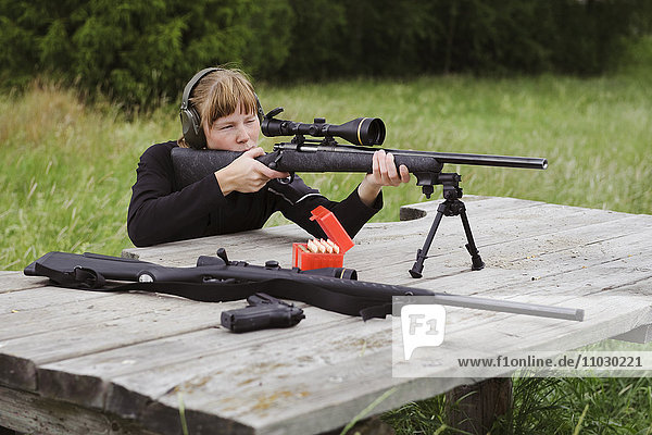 Woman target shooting in meadow