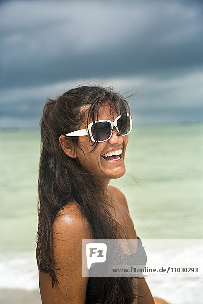 Lachende junge Frau am Strand