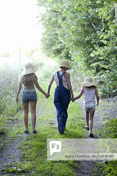 Mutter mit zwei Töchtern geht durch den Wald