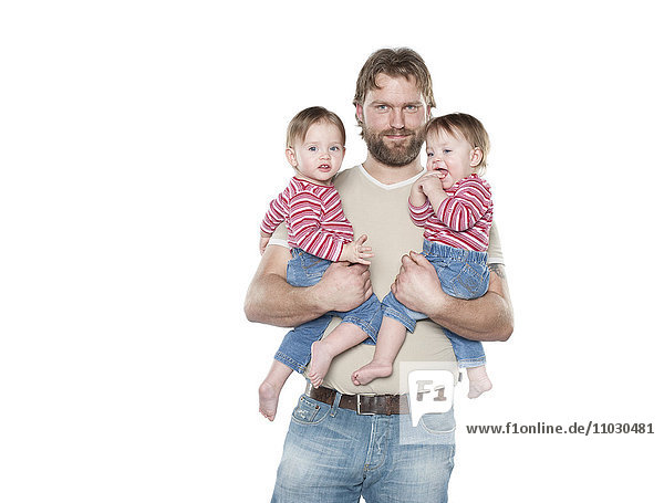 Studio-Porträt eines Vaters mit zwei kleinen Töchtern