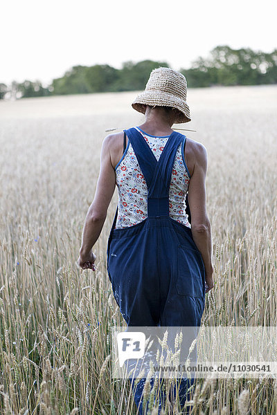 Frau geht auf Weizenfeld