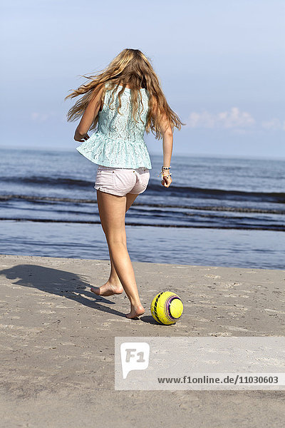 Teenager-Mädchen spielt am Strand