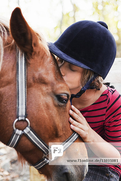 Ein Mädchen küsst ein Pferd