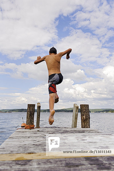 A boy running  jumping on a jetty