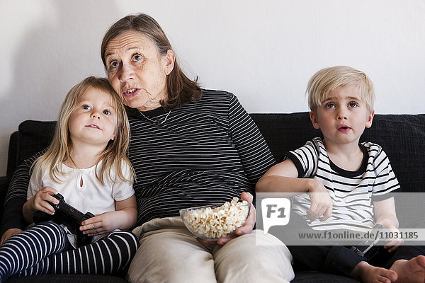 Grandmother with grandchildren playing video games
