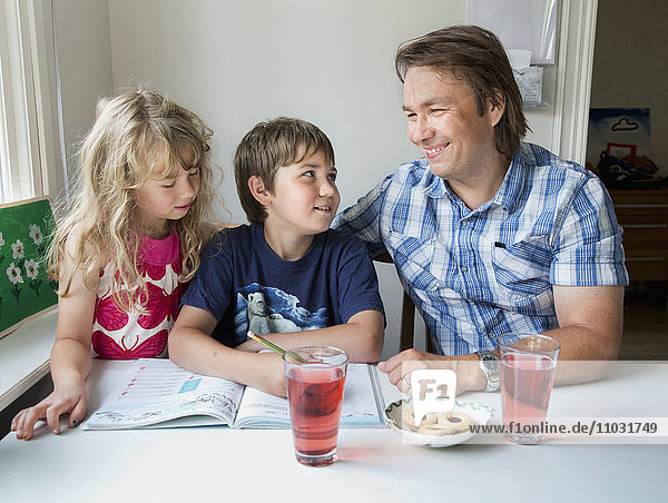 Junge und Mädchen machen mit ihrem Vater Hausaufgaben  Stockholm  Schweden