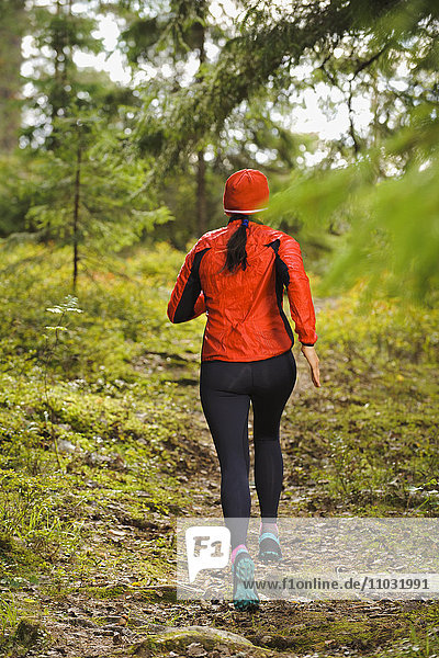 Woman jogging through forest