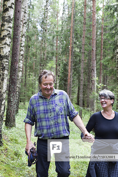 Mature couple walking through forest