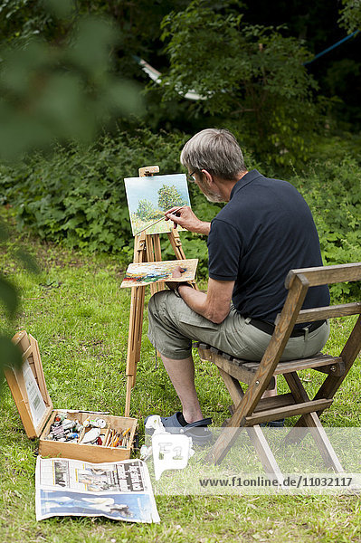 Man painting in his back yard