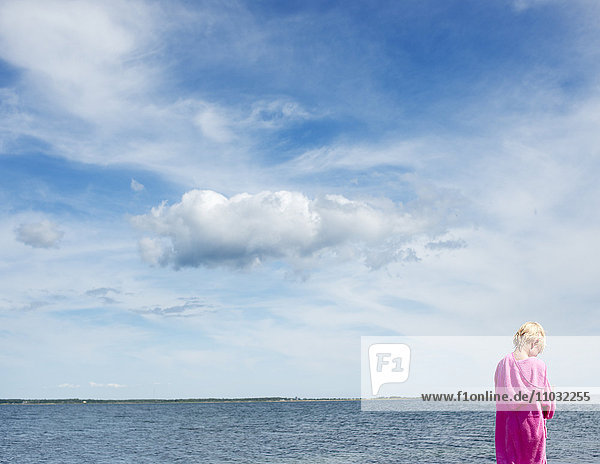 A boy in a bathrobe at the ocean
