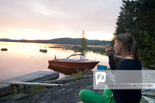 Frau beim Essen am See  Siljan  Dalarna  Schweden