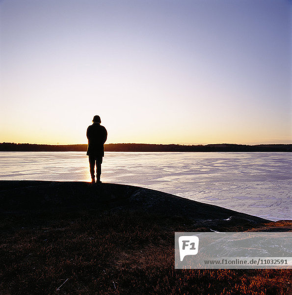 Silhouette einer Person am Meer.