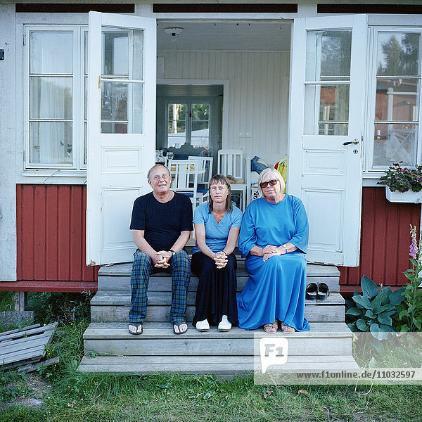 Frau mit älteren Eltern vor der Haustür  Schweden