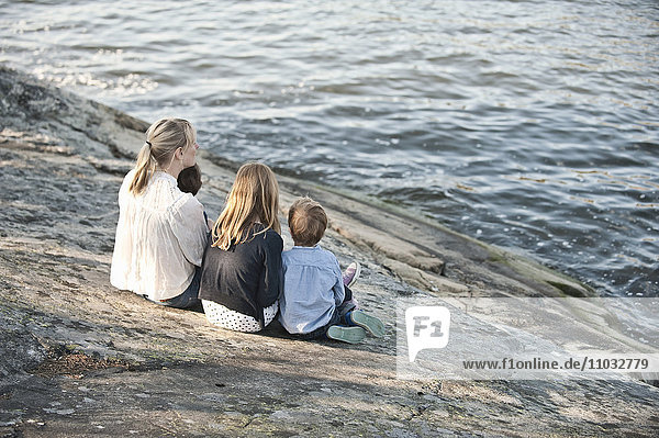 Mother with three children sitting at water  Nacka  Sweden