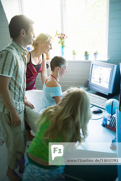 A family gathered around a computer.