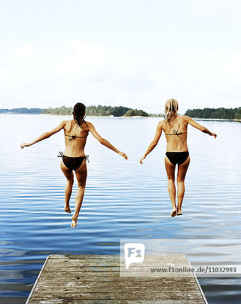 Zwei Frauen springen ins Wasser.
