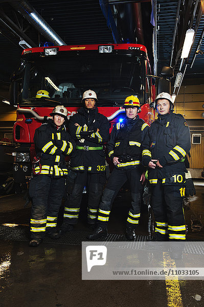 Portrait of fire fighters in front of fire engine