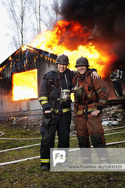 Feuerwehrleute vor einem brennenden Gebäude