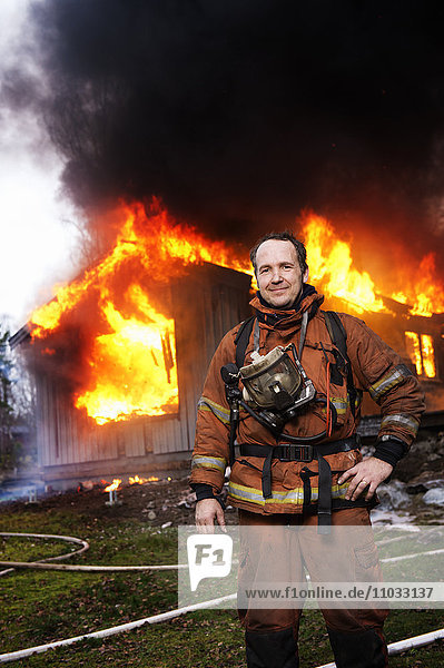 Feuerwehrmann vor einem brennenden Gebäude