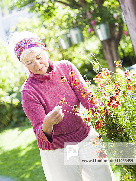 A woman pottering in her garden.