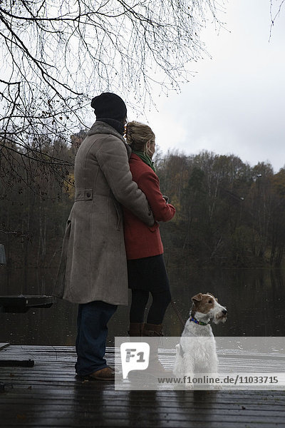Ein Paar auf einer Promenade mit einem Hund.