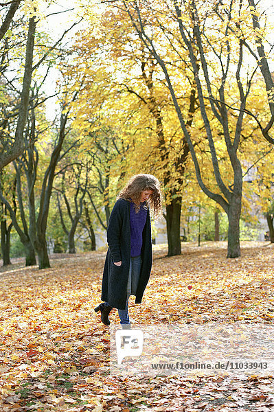 Smiling woman walking in autumn park