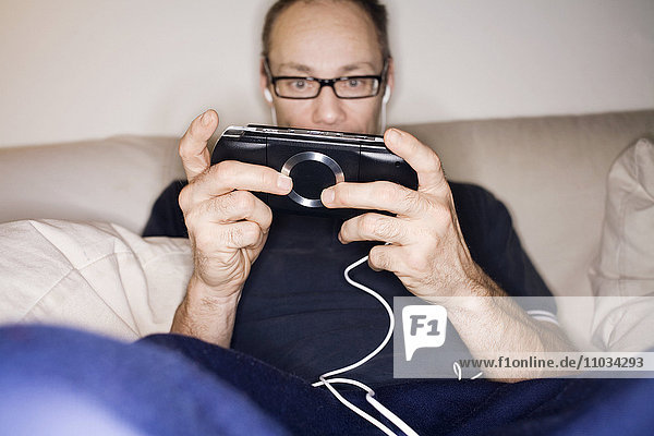 A man playing video game on a psp  Sweden.