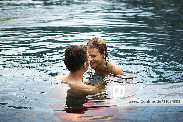 A young scandinavian couple bathing in a swimmingpool  Thailand.