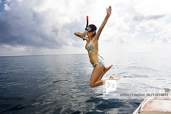 A woman jumping into the sea  Thailand.