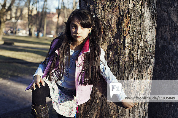 Portrait of girl standing near tree