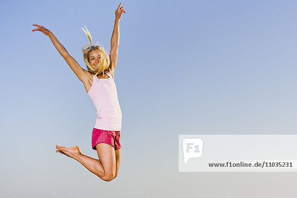 Glückliche junge Frau beim Springen