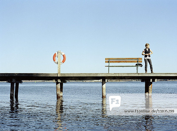 Eine junge Frau auf einem Bootssteg  Schweden.