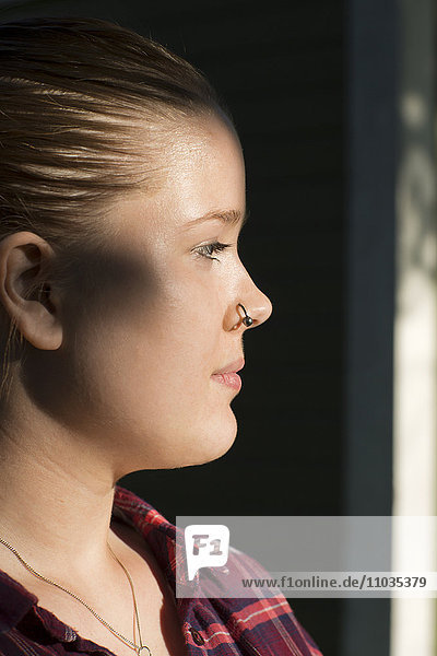 Profil einer jungen Frau mit Nasenring