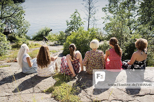 Mehrgenerationenfamilie sitzt zusammen und schaut aufs Meer