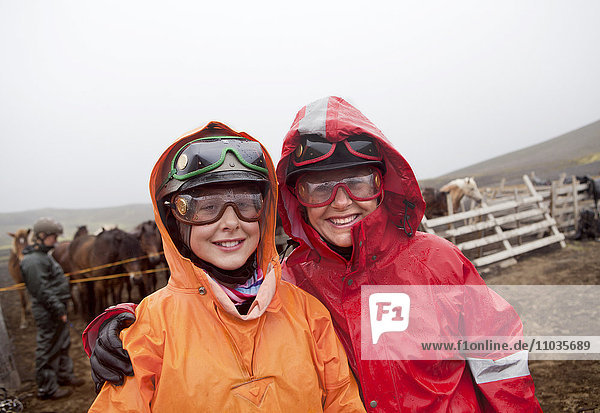 Porträt einer Frau und eines Mädchens mit Regenmantel und Schutzbrille