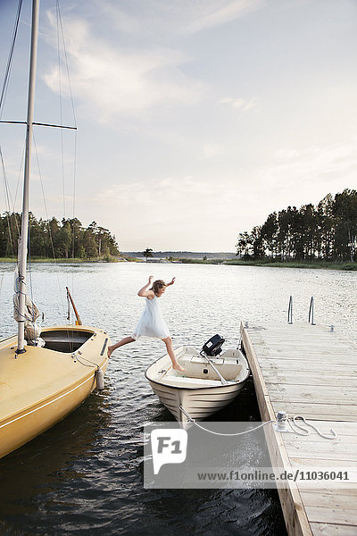 Girl jumping from boat into boat