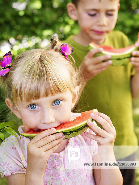 Junge und Mädchen essen Wassermelone  Schweden.