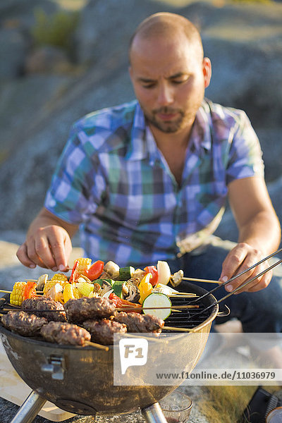 A man barbecuing  Stockholm archipelago  Sweden.